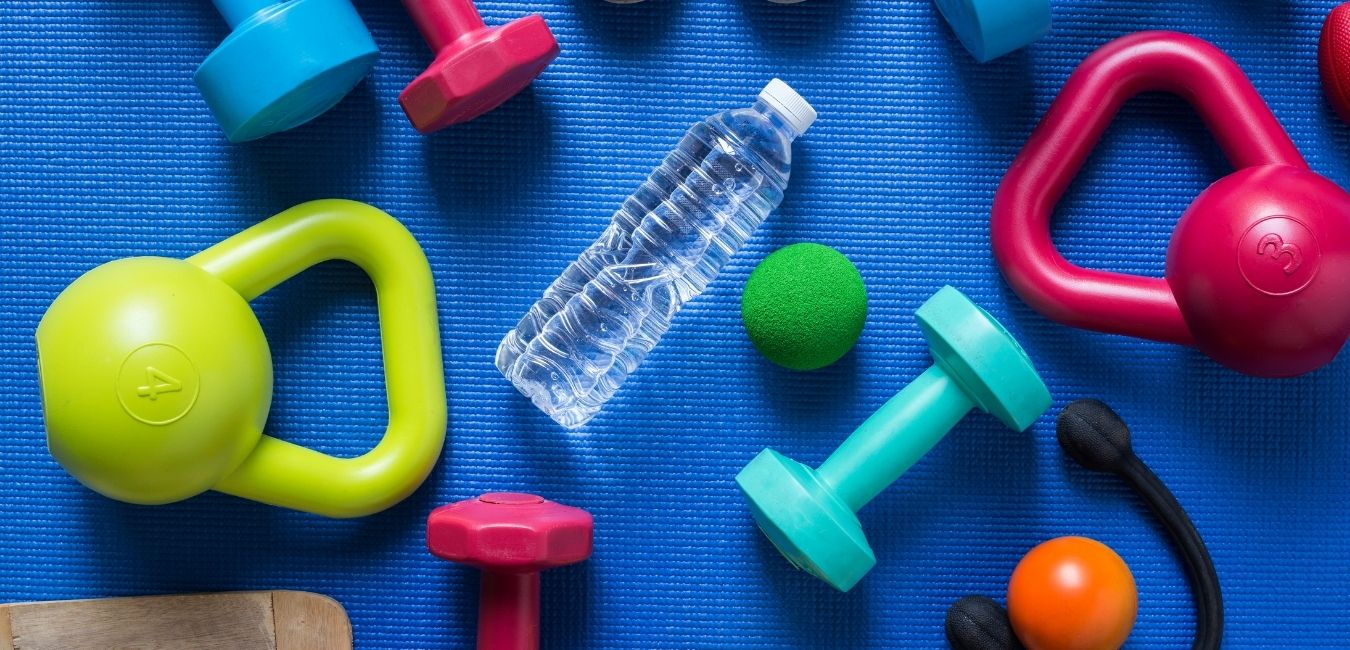 If Freedom is a Priority, Fitness will Follow - blue yoga mat with colorful hand weights, kettle bells and a water bottle.